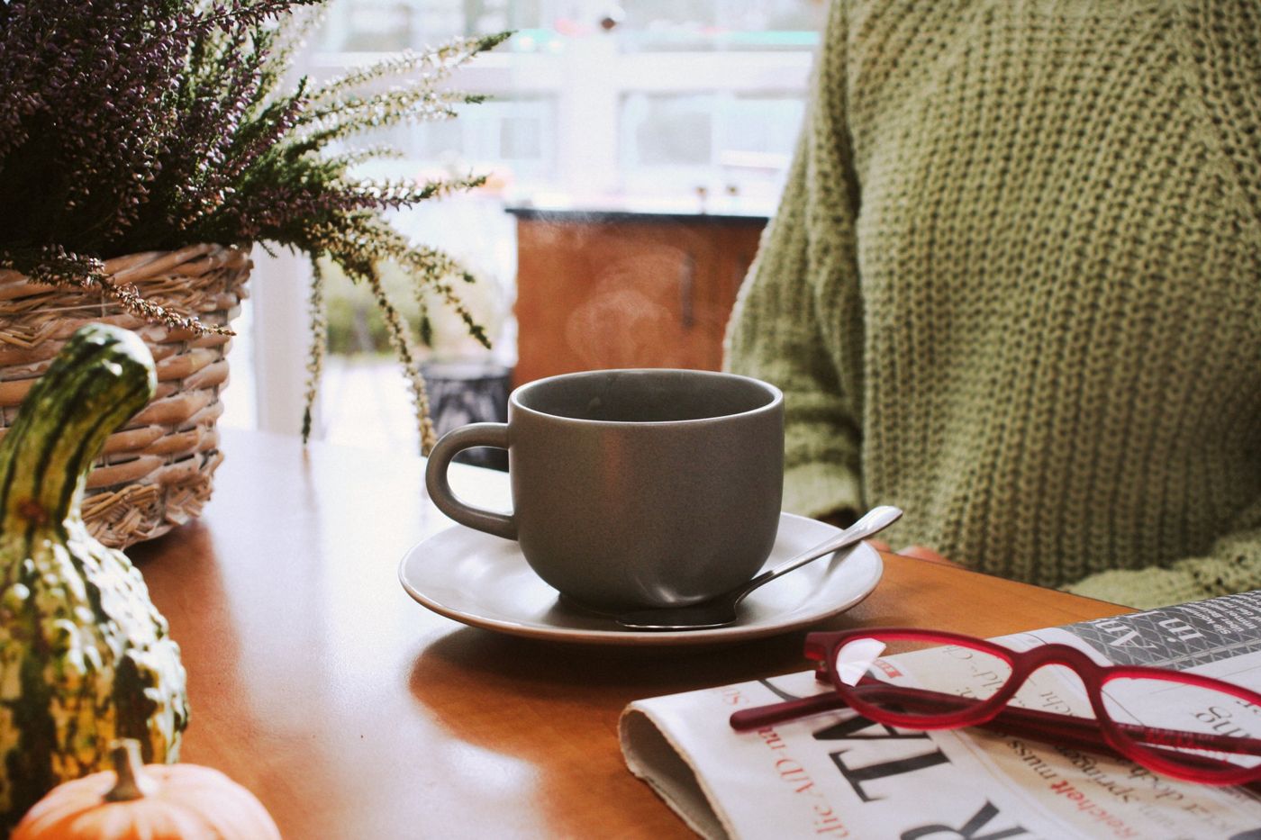 Gemütlicher Tisch zu Hause mit Tasse und Lesebrille